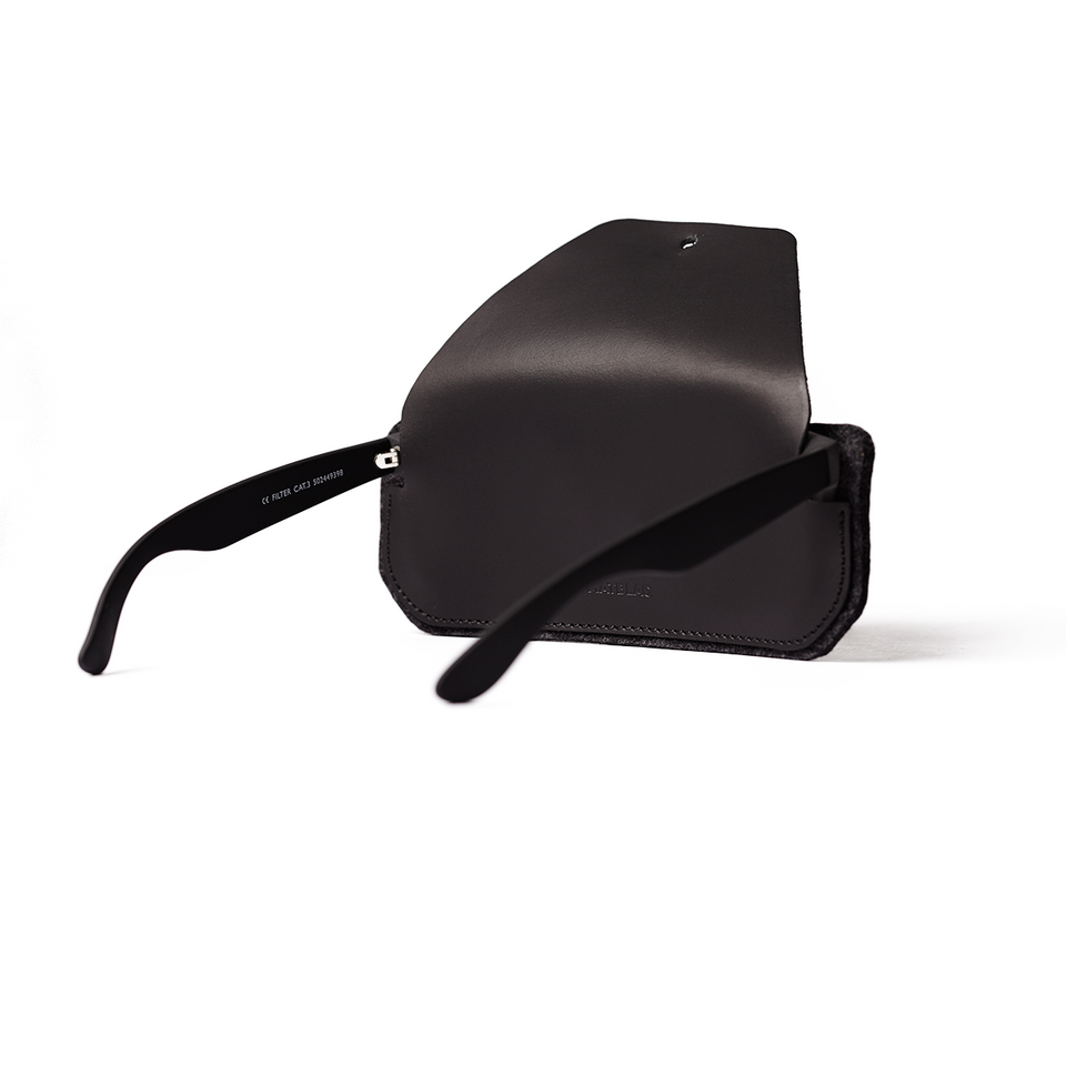 Black leather and felt sunglass case on white background