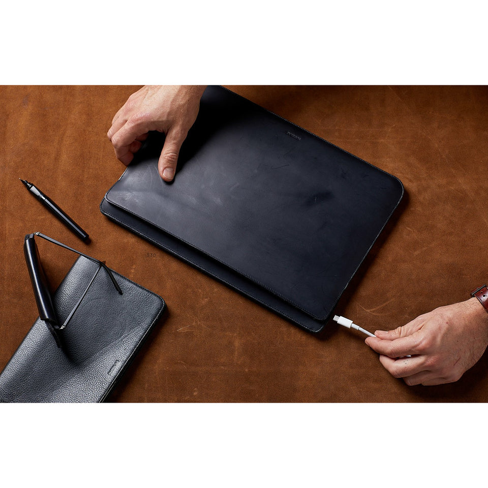 Lifestyle shot of minimalist black genuine leather laptop bag with charger port